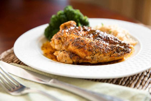 GarlicLimeChicken Baked chicken breast on white plate with broccoli and rice