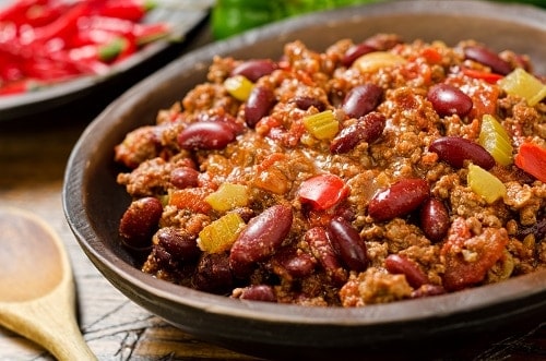 A hearty bowl of chili con carne with hot peppers.