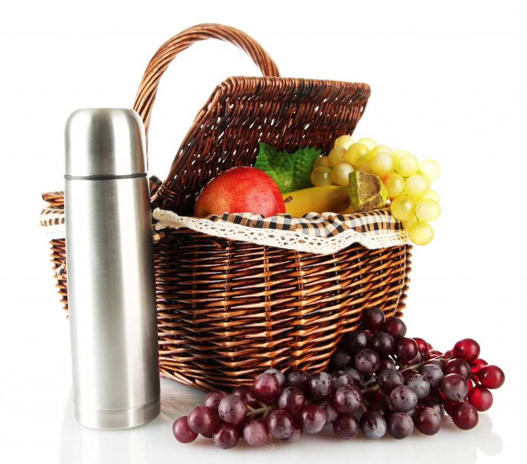 Picnic basket with fruit and thermos isolated on white